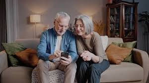 Well-dressed elderly couple using a smartphone together