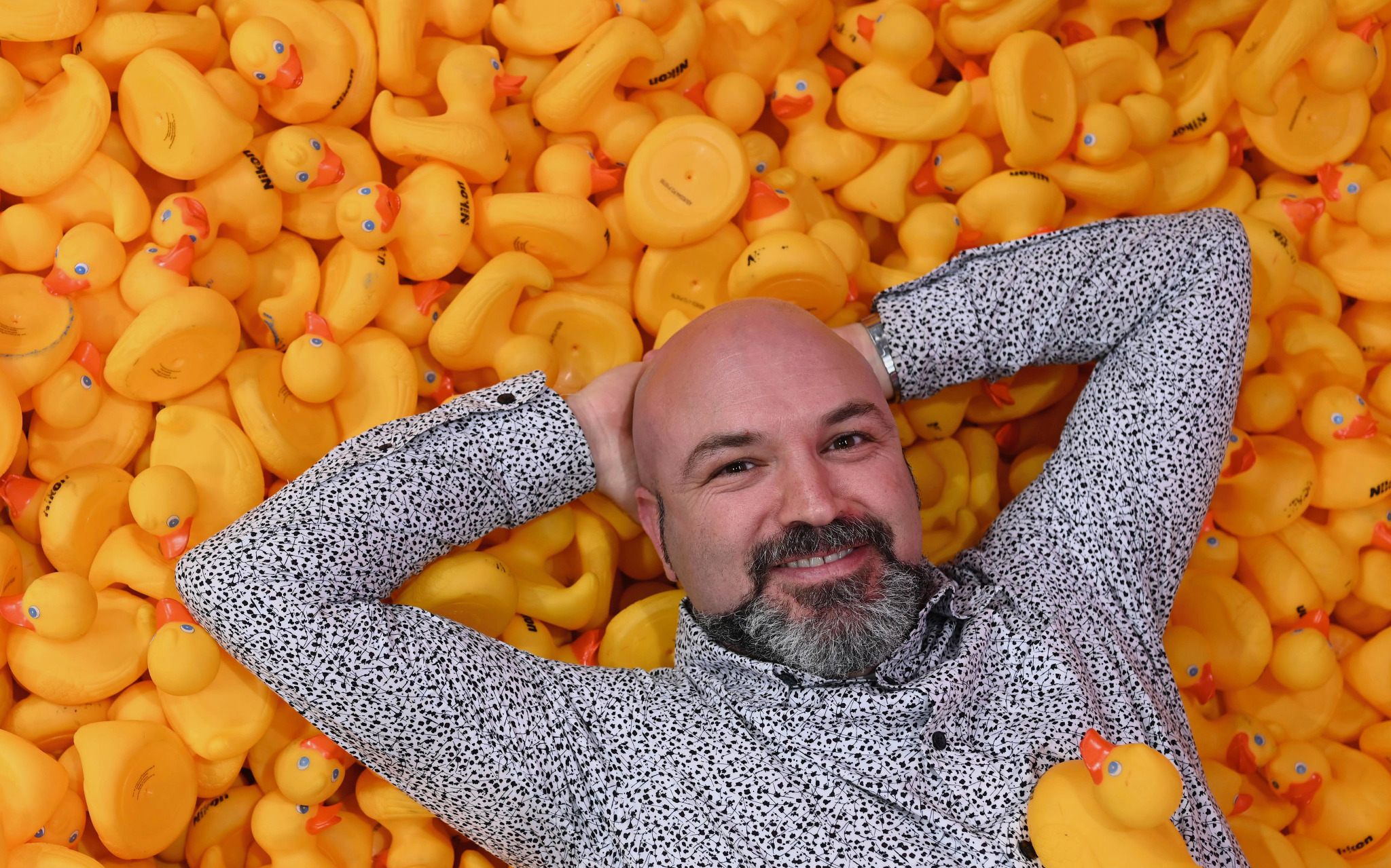 Ramis Sadrieh reclining on yellow rubber ducks