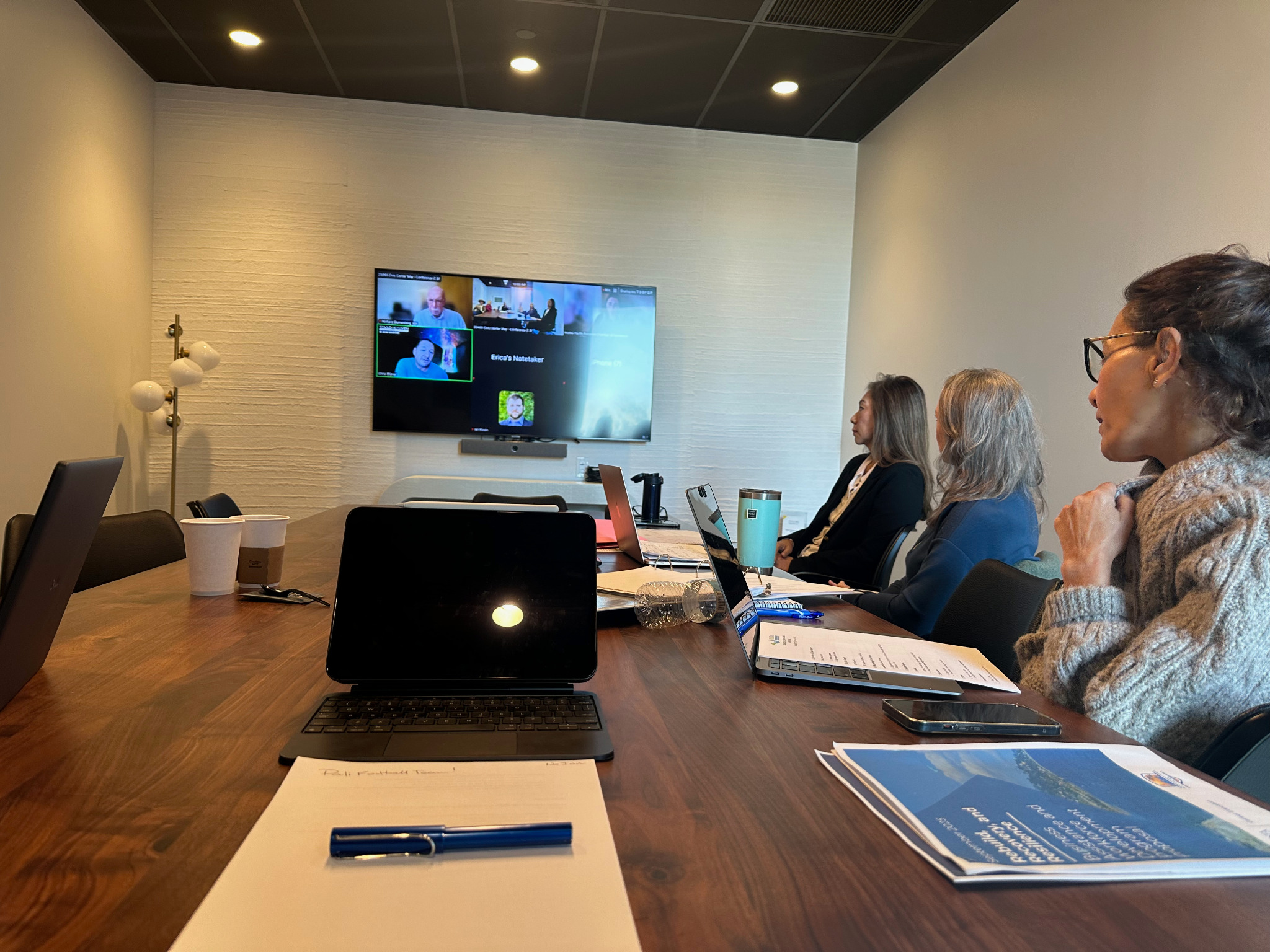 Conference room technology setup with wall display and laptops